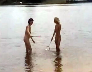Slim nude maidens frolicking badminton on a sea beach.